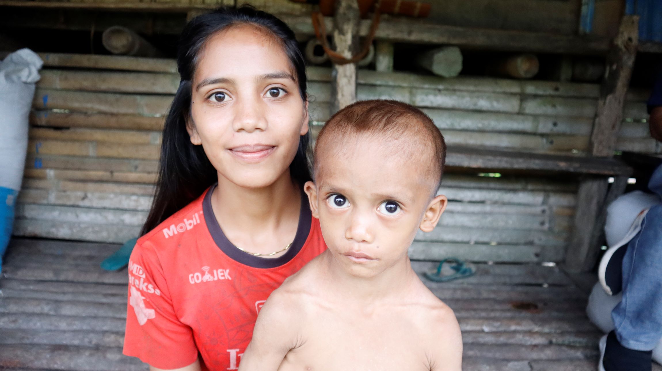 Julio Harsen Sogara saat digendong oleh Kakak kandungnya Yusinta Bili dirumah kediaman mereka di kampung Wanno Muttu, desa Kalembu Kanaika, Kecamatan Wewewa Barat, Kabupaten Sumba Barat Daya, Provinsi Nusa Tenggara Timur. FOTO : Timesntt.com