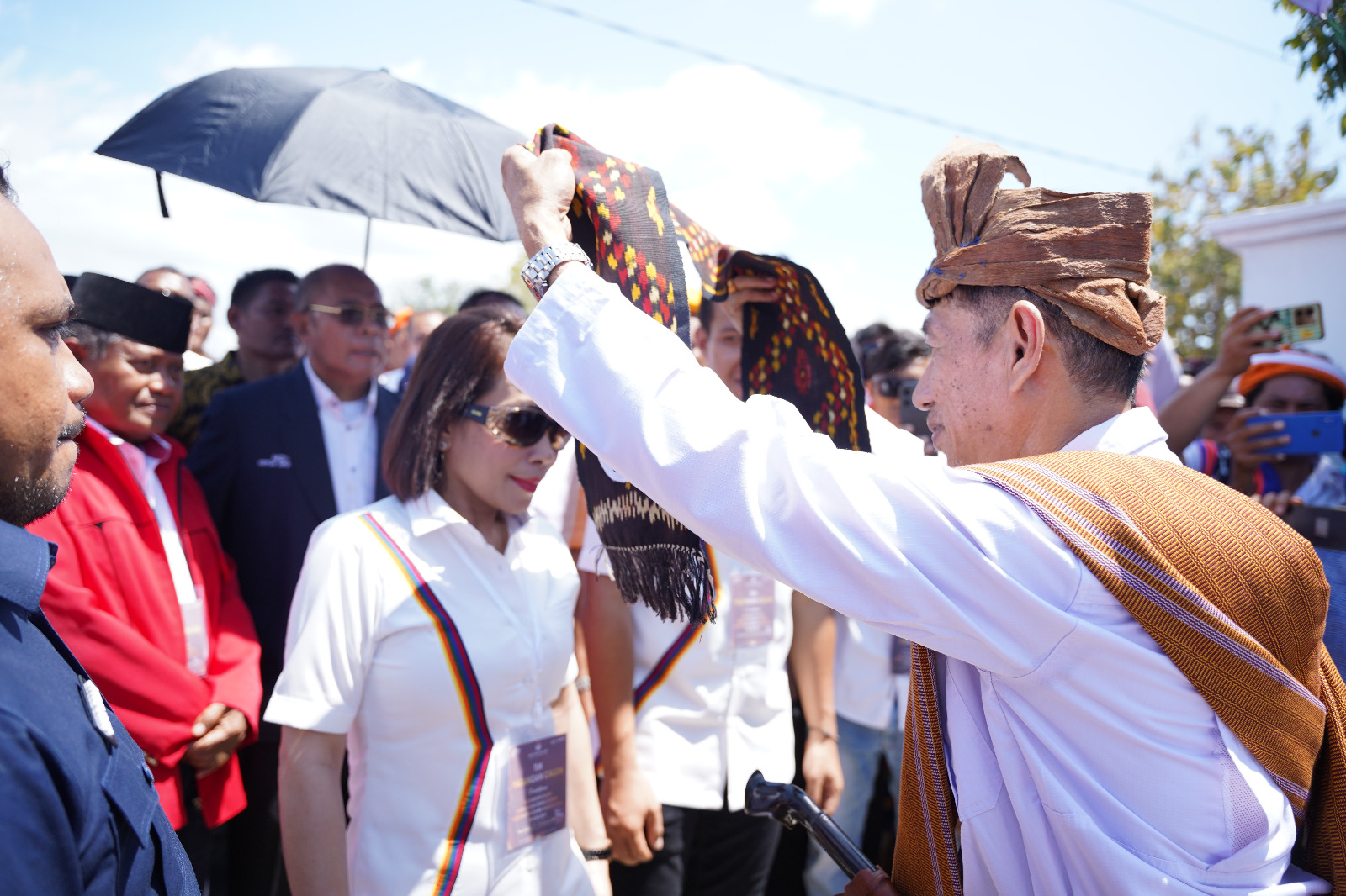 Ketua KPU Sumba Barat Daya (SBD) Hyronymus Malelak saat memberikan selempang kepada bakal calon Bupati SBD, Ratu Ngadu Bonnu Wulla di pintu gerbang utama kantor KPU SBD.